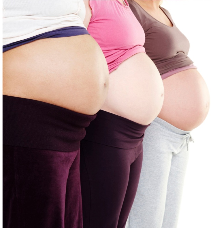 A cropped image of three women's pregnant bellies standing in a row - copyspace